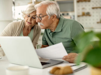 senior couple analyzing their savings while going through home finances scaled