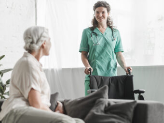 senior-woman-looking-smiling-female-nurse-with-wheelchair senior woman looking smiling female nurse with wheelchair scaled