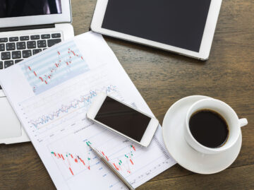 Laptop, tablet , smartphone and coffee cup with financial docume top view colorful business report cup coffee scaled