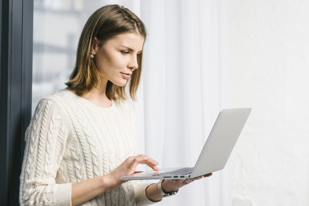 lovely woman using laptop near window