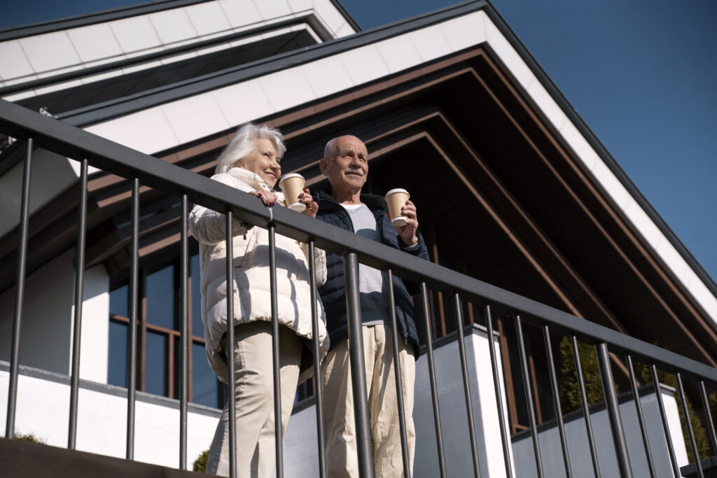low angle smiley senior couple with coffee cups